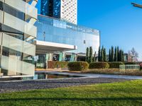 an open courtyard area has green grass, trees, and buildings on the other side