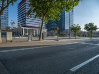 an empty street in front of a building and trees on the other side of the road