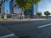 an empty street in front of a building and trees on the other side of the road