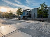 a street with trees, water, building and pavement in the background is a manhole with no name