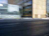 a black truck driving on a city street near buildings, bluring at the camera
