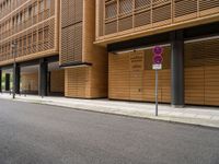 the building near the street has two street signs on the sidewalk in front of it