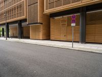 the building near the street has two street signs on the sidewalk in front of it