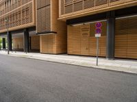 the building near the street has two street signs on the sidewalk in front of it