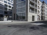 an empty street with tall building in the background and a graffiti on the ground below