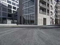 an empty street with tall building in the background and a graffiti on the ground below