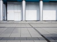 an image of empty parking lot with two cars in front of it and people walking in line