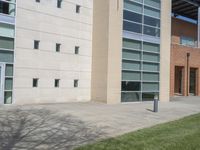 the grass in front of the building looks nice in the shade and shadows of the sun