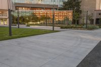 a person rides a skateboard down an asphalt road in front of a building with glass on it