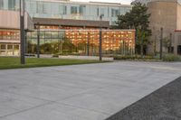 a person rides a skateboard down an asphalt road in front of a building with glass on it