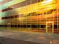 there is an empty sidewalk in front of a large building with glass walls and stairs