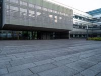 a walkway is shown outside an office building with windows in front of it and light reflecting off the facade on a dark day