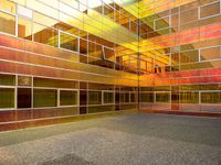 the outside of an office building that looks very colorful with reflections in it's glass