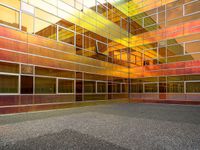 the outside of an office building that looks very colorful with reflections in it's glass