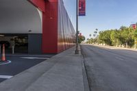 a red building on the side of an empty road with cones in front of it