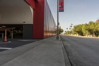 a red building on the side of an empty road with cones in front of it