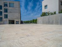 the gray concrete walls of a building have a line of steps on the left side