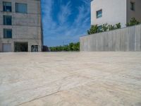 the gray concrete walls of a building have a line of steps on the left side