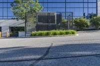 empty street in front of an office building, with large glass windows and black door