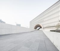 a man in shorts is standing on his skateboard near a wall by the building