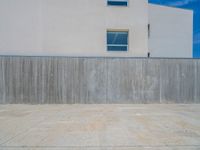 the gray concrete walls of a building have a line of steps on the left side