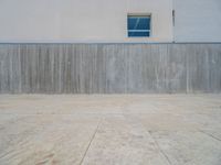 the gray concrete walls of a building have a line of steps on the left side