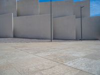 the gray concrete walls of a building have a line of steps on the left side