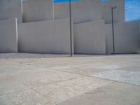 the gray concrete walls of a building have a line of steps on the left side