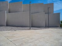 the gray concrete walls of a building have a line of steps on the left side