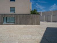 the gray concrete walls of a building have a line of steps on the left side