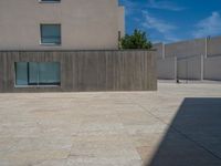 the gray concrete walls of a building have a line of steps on the left side