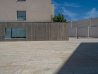 the gray concrete walls of a building have a line of steps on the left side