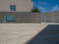 the gray concrete walls of a building have a line of steps on the left side