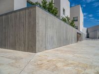 the gray concrete walls of a building have a line of steps on the left side