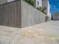 the gray concrete walls of a building have a line of steps on the left side