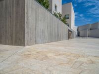 the gray concrete walls of a building have a line of steps on the left side