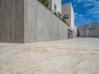 the gray concrete walls of a building have a line of steps on the left side