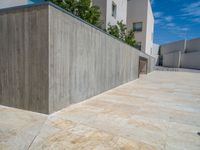 the gray concrete walls of a building have a line of steps on the left side