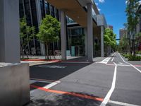 a city street with white lines painted in red and gray between two buildings and an urban area