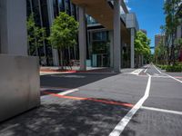 a city street with white lines painted in red and gray between two buildings and an urban area