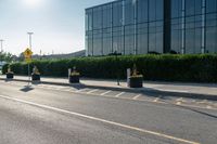 a empty street with trash cans in a building next to it and a yellow line on the curb