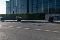 a empty street with trash cans in a building next to it and a yellow line on the curb