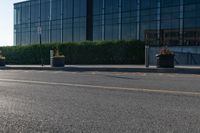 a empty street with trash cans in a building next to it and a yellow line on the curb