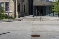 a sidewalk in front of a building with stairs up to the top of it,