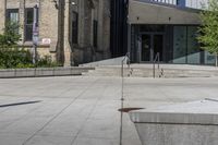 a sidewalk in front of a building with stairs up to the top of it,