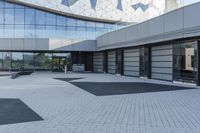 a view of an outside area of an office building with large windows and a circular driveway