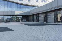 a view of an outside area of an office building with large windows and a circular driveway