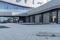 a view of an outside area of an office building with large windows and a circular driveway