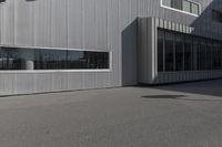 a white metal building with large windows on the outside of it and a fire hydrant at the top of it