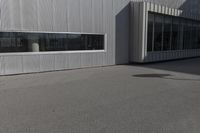 a white metal building with large windows on the outside of it and a fire hydrant at the top of it